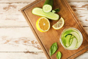 Fototapeta na wymiar Glass with cucumber lemonade on wooden background