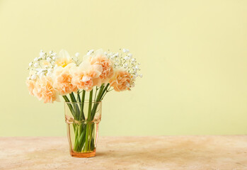 Vase with narcissus flowers on color background