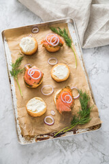 Gravlax Graved Lachs, ein roh gebeizter Fisch mit Dill auf Brötchen mit Frischkäse,  Zwiebelringe...