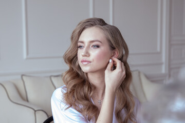 beautiful young girl in a white robe in a bright interior