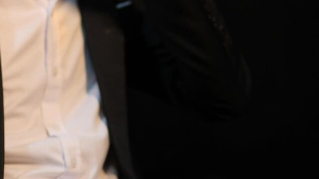 Man wearing a suit whiskey glass of liquor and a phone