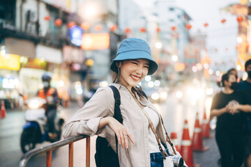 Young adult asian woman traveller backpack traveling in city lifestyle chinatown street food  with bokeh background.