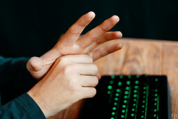 Angry gamer show gestures. Man shows sings of future victory or defeat. Neon keyboard on a wooden table. Streamer and gamer concept.