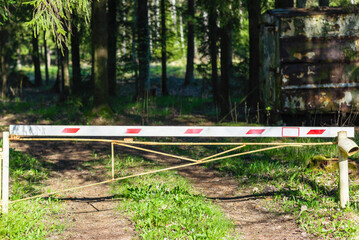 Obraz na płótnie Canvas Boom barrier near path road. It is forbidden to enter the forest park on sunny day.