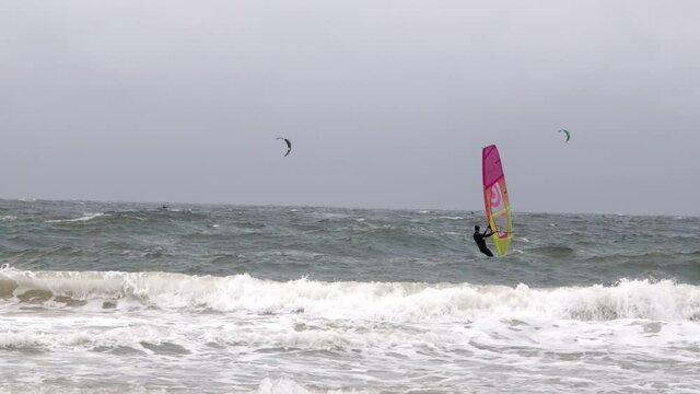 extreme wind at the north sea. surfers surf on very high waves at the beach of westerland. Storm warning on Sylt