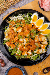 Gado Gado is an Indonesian salad of slightly boiled, blanched or steamed vegetables and hard-boiled eggs, boiled potato, fried tofu and tempeh, and lontong, served with a peanut sauce dressing.
