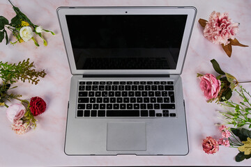 Computadora portátil con flores al rededor concepto femenino