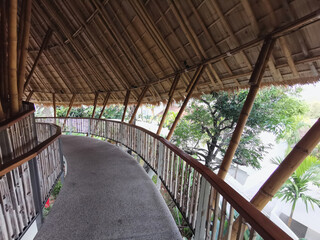 Leaf roof and bamboo structure with concrete walkway.