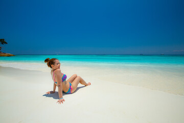 Woman in bikini Sunbathing on the white sandy beach on paradise island. In the Andaman Sea , Thailand