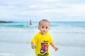 The baby's boy smiling happily to come to the sea. With family on vacation.