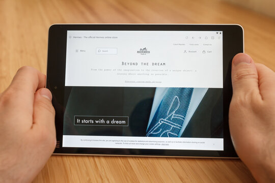 SAN FRANCISCO, US - 1 April 2019: Close up to hands holding tablet using internet and looking through Hermes web site, in San Francisco, California, USA. An illustrative editorial image.