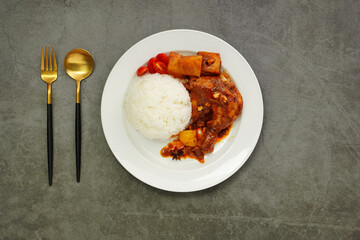 Homemade Massaman Chicken with Chili Paste, Coconut Milk , Steamed Rice on a White Plate
