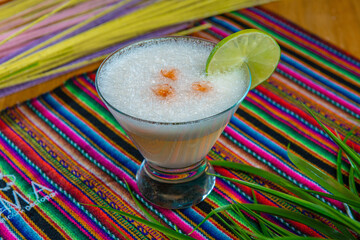 Traditional Peruvian pisco sour cocktail with a slice of lime