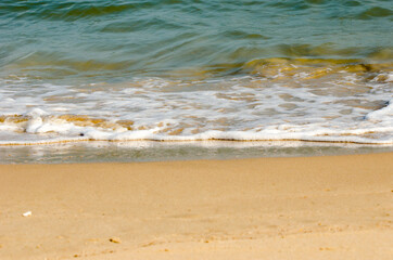 The lapping of the waves on the sandy beach.Small sea waves with crystal clear water on the sandy beach.
