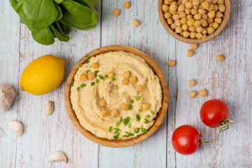 Bowl of tasty fresh hummus with tomatoes. chickpea hummus with vegetables on gray background