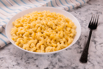 Macaroni and cheese on a white plate on a gray background