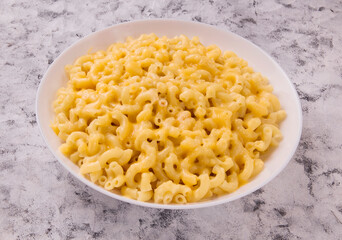 Macaroni and cheese on a white plate on a gray background
