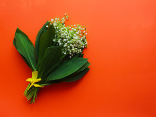 Spring or summer background. bouquet of lilies of the valley on a red background. view from above. copy space. spring flowers concept. Bright wallpaper