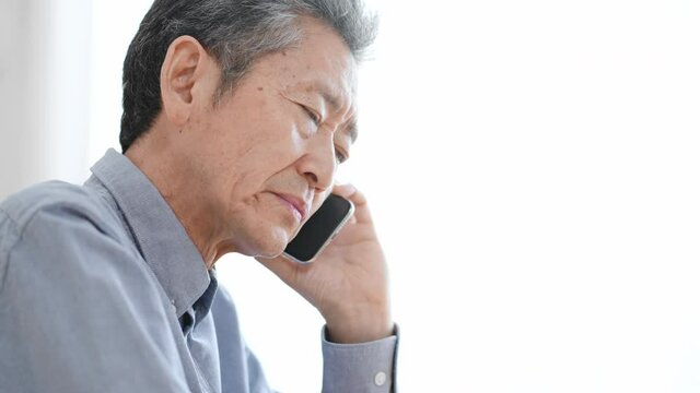 携帯電話で電話する高齢の男性　ネガティブ