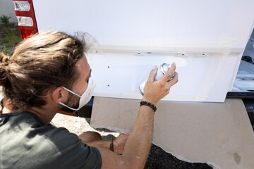 Man mending the varnish of a van