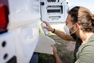 Man mending the varnish of a van