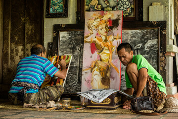 A painter sitting while painting a portrait on a studio in Bali, Indonesia © Marlon Hutajulu