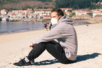 Fototapeta na wymiar man with medical mask on the beach relaxed in the new normal