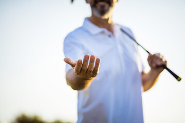 Golfer offers a helping hand. Focus is on hand.  Hand, open palm.