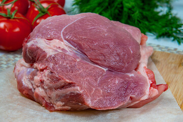 Raw pork meat on a wooden board with herbs