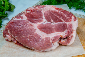 Raw pork meat on a wooden board with herbs