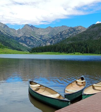 Tranquil scene of  canoes in the summer at piney lake against a gore range mountain  backdrop, near vail, colorado  
