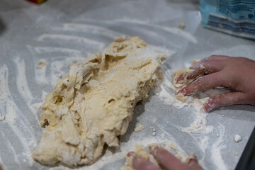 hands kneading dough on marble kitchen bench, baking cinnamon rolls from scratch