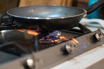 stainless steel pan, frying pan on stove top with flame heating it up