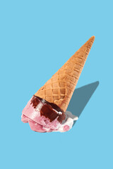 the ice cream in the cone fell to the floor and spread on a blue background. The concept of failure and frustration.