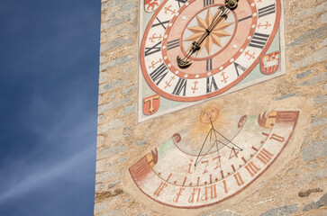 The recently restored clock and  sundial painted outside the bell tower of the church of the town.