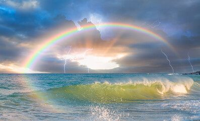 Beautiful landscape with rainbow and lightning over the calm sea at sunset 