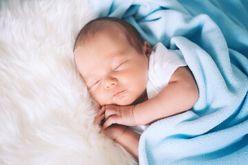 Newborn sleep at first days of life. Portrait of new born baby one week old in crib in cloth...