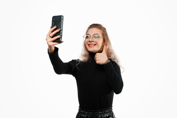 Fototapeta premium Video communication via smartphone. A young woman is using phone for video call. She talks with her friends