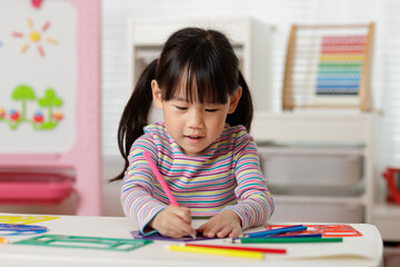 young girl drawing different shapes for homeschooling