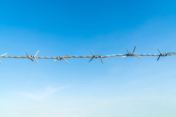 Barbed wire isolated fence with blue sky