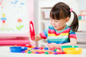 young girl play math and color sorting fine motor skill game for  homeschooling