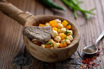 Central Asian food Nohatshurak soup with peas, vegetables and spices. Uzbek and Central Asia cuisine concept. Side view