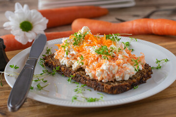 Sandwich with cottage cheese and grated carrots on a plate