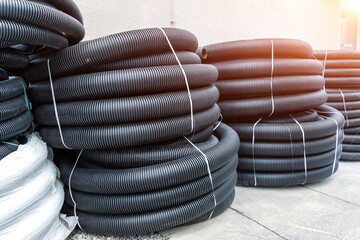 Many rolled colis of new black corrugated goffred plastic electric plumbing drainage pipe prepared...