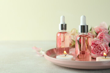 Skin care concept with essential rose oil on white textured table
