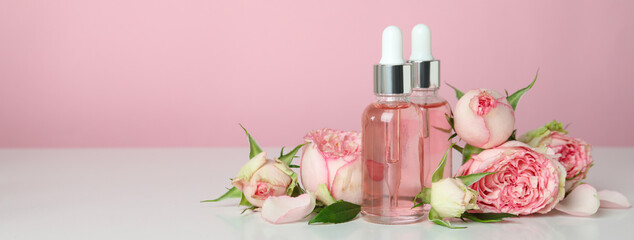 Skin care concept with essential rose oil on pink background