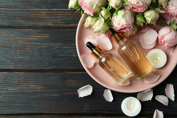 Skin care concept with essential rose oil on wooden table