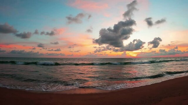 Colorful sunset over sea water n ocean wave at sandy beach