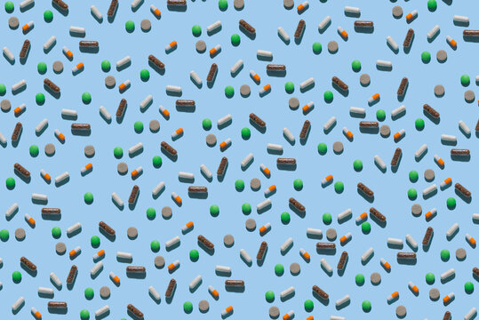 Medication pattern in modern style with hard shadows, flat lay. Medicines on a light blue background in the form of a seamless pattern. Irregular pattern.