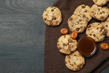 Napkin with cookies and caramel on dark wooden background